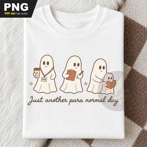 May include: A white t-shirt featuring a graphic of three ghosts in brown outlines. One ghost holds a coffee cup and wears a lanyard, another holds a clipboard and pencil, and the third helps a smaller ghost read a book. Text reads: Just another para normal day.