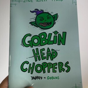 May include: A light blue zine titled "Goblin Head Choppers" with a green goblin illustration. The text includes "ZINE QUEST TTRPG" and "Dwarfs vs Goblins" with the author's name, ALG040.