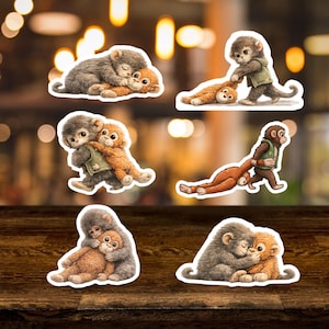 May include: A collection of sticker designs featuring cartoon monkeys in various poses. The stickers depict monkeys in shades of brown, gray, and orange, some hugging, others interacting. The stickers are on a wooden surface.