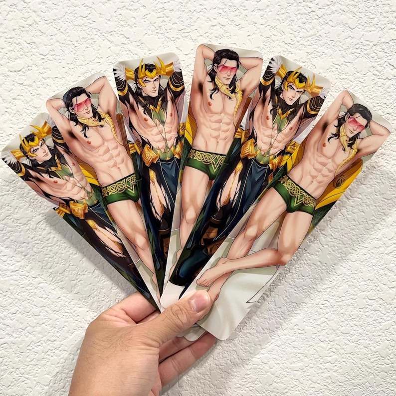 May include: A hand holds a fan of six illustrations. Each illustration depicts a muscular character with long black hair, wearing green and gold briefs, a gold crown, and pink sunglasses. The character is posed with their arms behind their head.