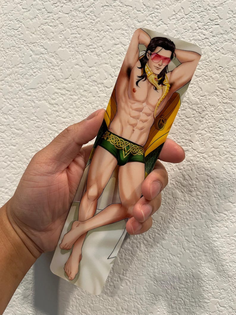 May include: A rectangular bookmark featuring an illustration of a muscular character with long black hair, wearing sunglasses, green shorts with a gold design, and a yellow scarf. The character is posed in a relaxed position.