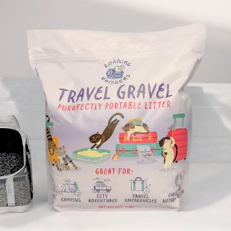 Op de afbeelding: Een witte zak "Travel Gravel" kattenbakvulling met illustraties van katten, koffers en reisgerelateerde iconen. De zak heeft de tekst "Purrfectly Portable Litter" en "Great For: Camping, City Adventures, Travel Emergencies, Natural Disasters". Netto gewicht: 1,8 kg.