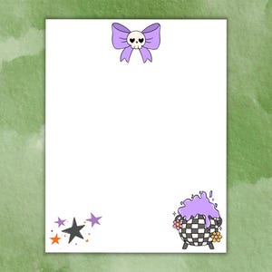 Pode incluir: Papelaria branca com ilustrações temáticas de Halloween. Um laço roxo com uma caveira no topo e um caldeirão com líquido roxo e flores no canto inferior direito. Estrelas em laranja, preto e roxo no canto inferior esquerdo.