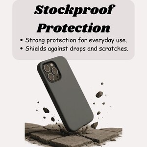 May include: A dark gray phone case with a matte finish, angled slightly to the left, with the text "Stockproof Protection" above it. The case is surrounded by broken stone, suggesting impact resistance. Text also states "Strong protection for everyday use" and "Shields against drops and scratches."