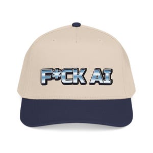 May include: A beige baseball cap with a dark navy blue brim and a top button. The front features the text F*CK AI in a metallic blue and silver gradient font with a black outline, centered on the crown of the cap with a structured five-panel design.
