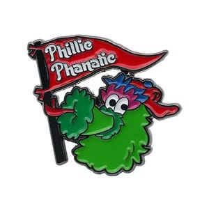 May include: A colorful enamel pin featuring the Phillie Phanatic mascot holding a red banner with the words "Phillie Phanatic" in white. The pin has a green body, blue hair, and a red tongue. The pin is a collectible item.