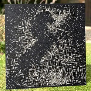 May include: A square black metal panel featuring a perforated design of a rearing horse. The image is created by varying densities of small circular holes that allow light to pass through, forming the silhouette of the horse against a dark background.