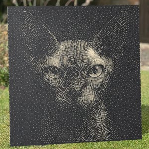 May include: A square black panel featuring a stippled portrait of a cat face created with numerous small white dots. The artwork uses varying dot density to define the feline features, including large ears, almond-shaped eyes, and a nose.