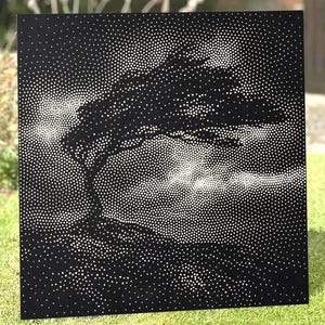 May include: A square black metal panel featuring a stippled design created with white dots. The pattern depicts a silhouette of a tree leaning in the wind against a cloudy sky, rendered entirely through varying densities of white circular perforations.