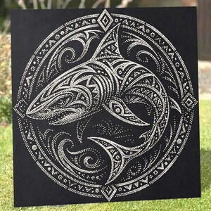 May include: A square black art piece featuring a white dot-art illustration of a shark swimming within a circular border. The shark and the surrounding circular frame are decorated with intricate patterns of small white dots and geometric shapes.