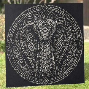 May include: A square black canvas featuring a white dot art illustration of a cobra snake. The snake is centered within a circular frame composed of intricate patterns, swirls, and geometric shapes, all created using small white dots on the dark background.