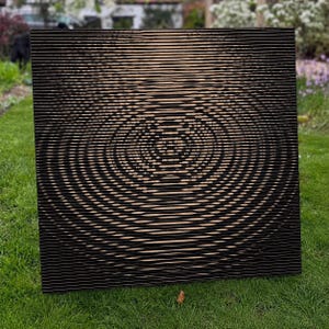 May include: A square wall art piece featuring a series of horizontal black slats layered over a light tan background. The slats are manipulated to create a central, circular ripple effect that appears to expand outwards from the middle of the panel.