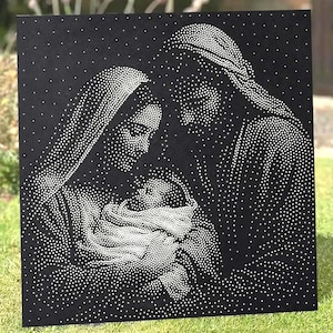 May include: A square black metal panel featuring a pointillist-style depiction of a nativity scene. The image is created using numerous small white dots that form the silhouettes of two figures leaning over a central infant wrapped in cloth.