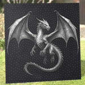 May include: A square black wall art piece featuring a white stippled illustration of a dragon with large wings and a long tail. The dragon is composed of numerous small white dots against a solid black background, creating a high-contrast image.