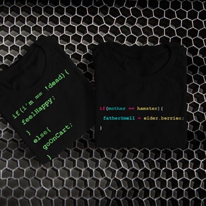May include: Two black t-shirts with green and blue code printed on them. The code on the left shirt reads: "if (i'm == !dead) { feelHappy; } else { goOnCart; ". The code on the right shirt reads: "if (mother == hamster) { fatherSmell = elder.berries; "