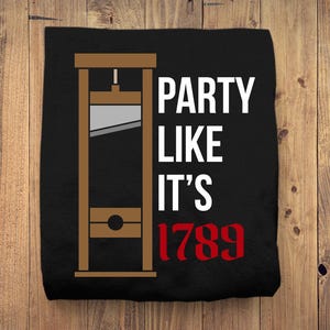 May include: Black t-shirt with a graphic of a guillotine and the text "Party Like It's 1789".
