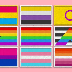 Puede incluir: Nueve banderas del orgullo diferentes, cada una con un esquema de color y un diseño diferentes, se muestran sobre un fondo rosa. Las banderas son todas rectangulares y tienen un borde blanco.