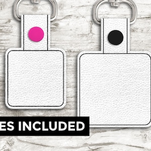 May include: Two white, square keyrings with a textured surface, black trim, and a silver keyring. One keyring has a pink circle, the other a black circle. The text "7 SIZES INCLUDED" is displayed in a black banner.