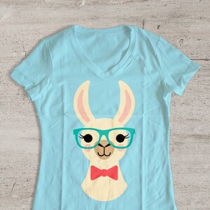 May include: A light blue t-shirt with a cartoon llama wearing teal glasses and a red bow tie.