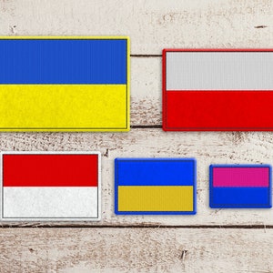 Puede incluir: Cinco parches de tela con diferentes diseños de banderas. La fila superior presenta una bandera azul y amarilla y una bandera blanca y roja. La fila inferior presenta una bandera roja y blanca, una bandera azul y amarilla y una bandera rosa y azul.