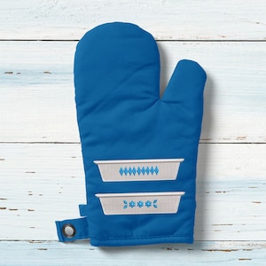 May include: Blue oven mitt with two embroidered white casserole dishes with blue floral designs.