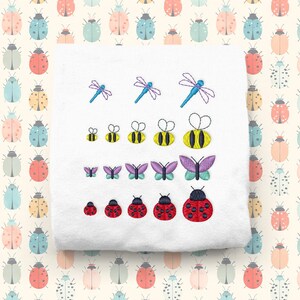 Puede incluir: Tela blanca con bordados de insectos: libélulas, abejas, mariposas y mariquitas. Los insectos son de varios tamaños y colores. Un patrón repetido de escarabajos coloridos en el fondo.