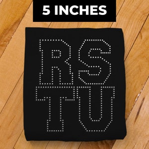 May include: Black fabric with the letters "RSTU" in white outlined with white dots. The fabric is 5 inches wide.