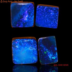 May include: Four rectangular loose opals with a dark base color and vibrant blue and purple flashes of light. The stones exhibit a polished surface with internal color play. The text Duty Paid – No Tariff and @ AL GANI GEMS is visible.
