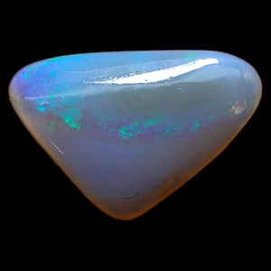 Könnte beinhalten: Ein dreieckiger, polierter Opal-Edelstein mit einer glatten, durchscheinenden weißen Basis und lebhaften, irisierenden blauen und grünen Lichtreflexen auf der Oberfläche, vor einem einfarbigen schwarzen Hintergrund.