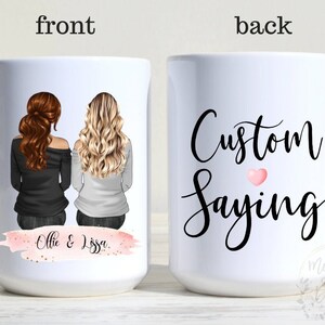 May include: White ceramic mug with a watercolor-style pink and gold design on the front. The design features two women with long hair, and the text "Ollie & Lissa". The back of the mug has black text that says "Custom Saying" with a pink heart.