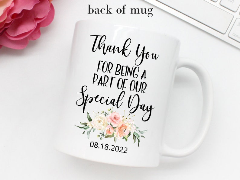 K&ouml;nnte beinhalten: Wei&szlig;e Keramiktasse mit einer schwarzen Aufschrift, die lautet "Vielen Dank, dass du Teil unseres besonderen Tages warst" mit einem Blumenmuster und dem Datum "08.18.2022".