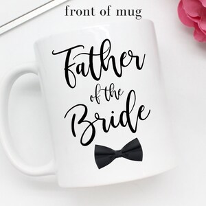 May include: White ceramic mug with a black bow tie and the text "Father of the Bride" in black calligraphy.