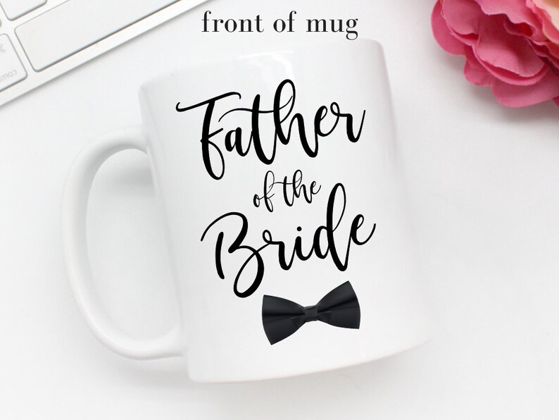 May include: White ceramic mug with a black bow tie and the text "Father of the Bride" in black calligraphy.