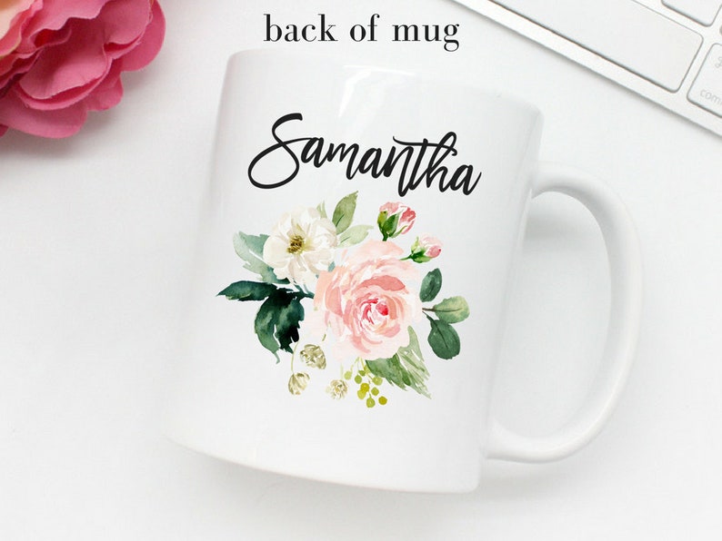 以下が含まれることがあります： 白いセラミック製のマグカップで、黒い花の模様と前面に「Samantha」という名前が印刷されています。