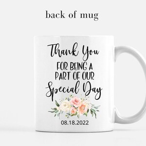 K&ouml;nnte beinhalten: Wei&szlig;e Keramiktasse mit einem schwarzen Blumenmuster und dem Text "Thank You for being a part of our Special Day" und dem Datum "08.18.2022".