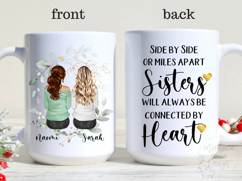 May include: White ceramic mug with a floral design and two women's illustrations on the front. The back of the mug has the text "Side by Side or Miles Apart Sisters Will Always Be Connected By Heart" with gold hearts.