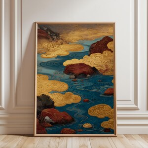 May include: Framed art print showing a stylized landscape. The artwork features a river with blue water, surrounded by reddish-brown rocks and golden clouds. The piece is framed in a light brown wooden frame.
