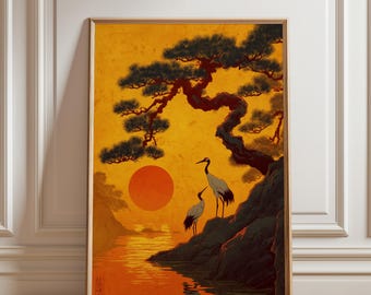 May include: A framed art print showcasing a Japanese landscape. The image presents an orange sunset over water, with two cranes on a rocky outcrop. A large tree with dark green foliage frames the scene, creating a tranquil and natural composition.