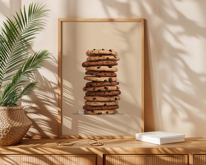 May include: A framed vertical wall art print featuring a tall, centered stack of round chocolate chip cookies. The illustration uses shades of brown and tan against a solid beige background, showcasing the textured edges of each cookie.