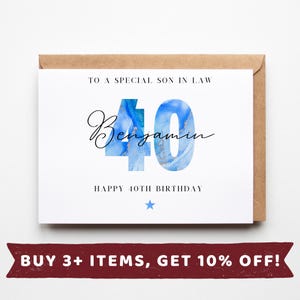 May include: A white birthday card with a brown envelope. The card says "TO A SPECIAL SON IN LAW" and "HAPPY 40TH BIRTHDAY." The number "40" is blue with a marble effect, and the name "Benjamin" is written in cursive.