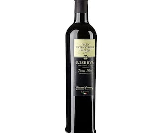 May include: A dark glass bottle of olive oil with a black cap. The label features the text "Olio Extra Vergine di Oliva" and "Riserva Tonda Iblea". The bottle is filled with a dark liquid, likely olive oil.