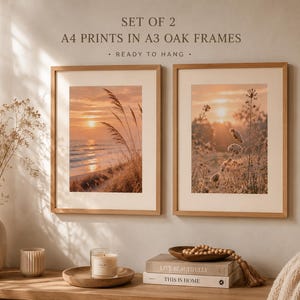 May include: Two framed A4 prints in A3 oak frames. The prints show a sunset over the sea and a field of wildflowers. The frames are light brown. The text "SET OF 2 A4 PRINTS IN A3 OAK FRAMES READY TO HANG" is visible.