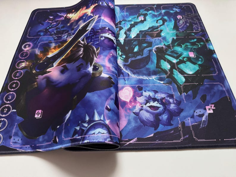Op de afbeelding: Een gaming muismat met een fantasie-illustratie. De mat heeft een donkerblauwe achtergrond met verschillende personages en elementen, waaronder een zwaardzwaaiend wezen en een pluizig paars personage. Genummerde ruimtes bevinden zich langs de linkerrand.