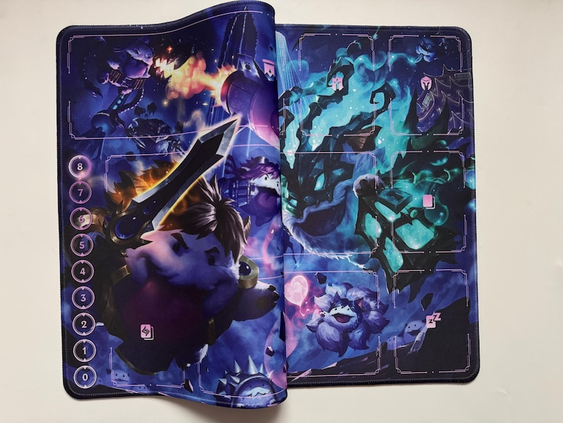 Op de afbeelding: Een gamingmat met een fantasiethema, met een levendige illustratie in tinten blauw, paars en oranje. Het kunstwerk toont personages met zwaarden en magische wezens. Genummerde ruimtes bevinden zich langs de linkerrand.