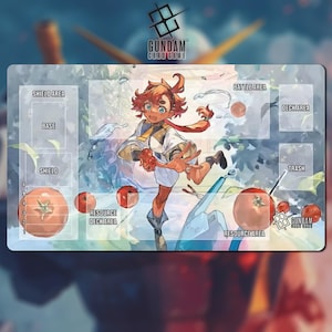 May include: A rectangular Gundam card game playmat featuring a colorful illustration of an anime character. The mat includes labeled areas for gameplay, such as "Shield Area," "Battle Area," and "Resource Area." The Gundam Card Game logo is visible.