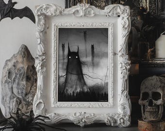 Puede incluir: Una impresión en blanco y negro enmarcada que presenta una figura oscura y ominosa con ojos brillantes y otras figuras sombrías en un entorno forestal. La impresión está en un marco blanco adornado, con un tema de Halloween.