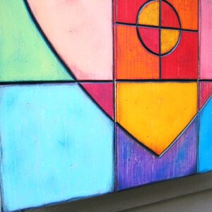 May include: A colorful geometric heart-shaped wall art piece made of wood. The heart is made up of squares and rectangles in shades of green, pink, red, orange, yellow, blue, and purple.
