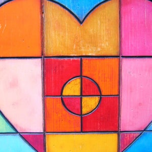 May include: A heart-shaped design made of wood painted in various colors, including orange, yellow, red, pink, green, and blue. The heart is divided into squares and circles, creating a geometric pattern.