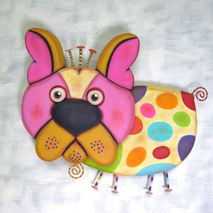 Puede incluir: Una escultura de perro de madera colorida. El perro presenta una cara rosa, orejas amarillas y un cuerpo con lunares multicolores. Tiene peque&ntilde;as patas de metal y detalles de cola rizada.