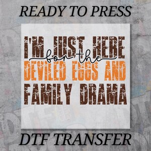 May include: A DTF transfer with the text "READY TO PRESS" at the top and "DTF TRANSFER" at the bottom. The main text reads "I'M JUST HERE for the DEVILED EGGS AND FAMILY DRAMA" in brown and orange.